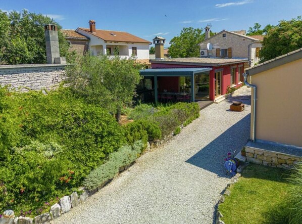 A residential property with a gravel driveway leading to a covered patio area. - Poolside Grand Retreat Villa (Sveti Lovrec)