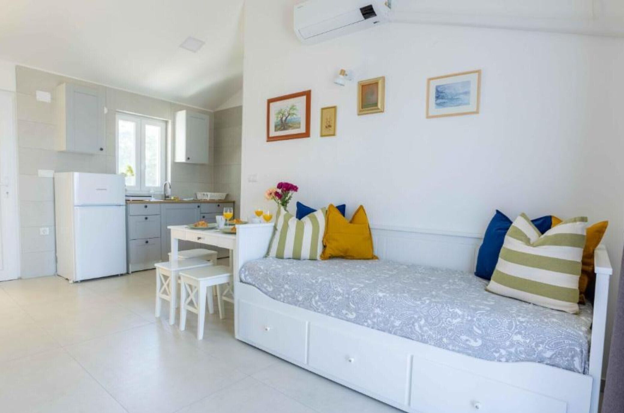 Una habitación compacta con cama, un escritorio pequeño y una kitchenette.