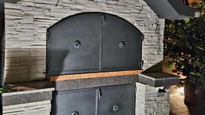 Een stenen muur met een zwarte grillstructuur.