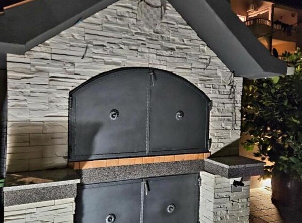 A stone wall with a black grill structure.