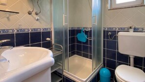A bathroom with a glass-enclosed shower, a white sink, and a toilet. - Apartments Lara Rab - One Bedroom Apartment with Balcony (Rab)