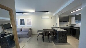 A modern kitchen with a dining area, a sofa, and a TV. - Faz Flat (Córdoba)