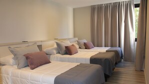 A hotel room with two beds, each with a pillow and a blanket. - Faz Flat (Córdoba)