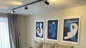 A modern living room with a sofa, a wooden coffee table, and abstract art on the wall. - Faz Flat (Córdoba)