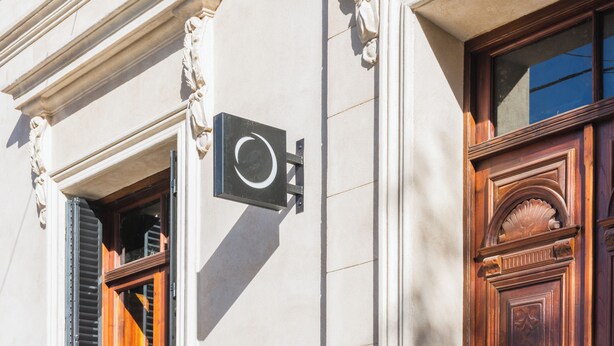 A building facade with classical architectural details, including ornate moldings and a wooden door. - Faz Flat (Córdoba)