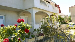 A two-story building with a balcony, arched windows, and a tiled roof. - One-Bedroom Apartment With Terrace And Sea View (A1) (Trogir)