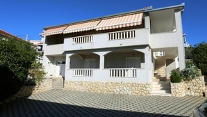 A two-story building with a stone foundation, a tiled entrance, and a red-tiled roof. - One-Bedroom Apartment With Terrace And Sea View (A1) (Trogir)