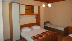 A compact bedroom with a bunk bed, a small desk, and a wardrobe. - Seafront Apartments Pretner - Studio with Terrace (Orebic)