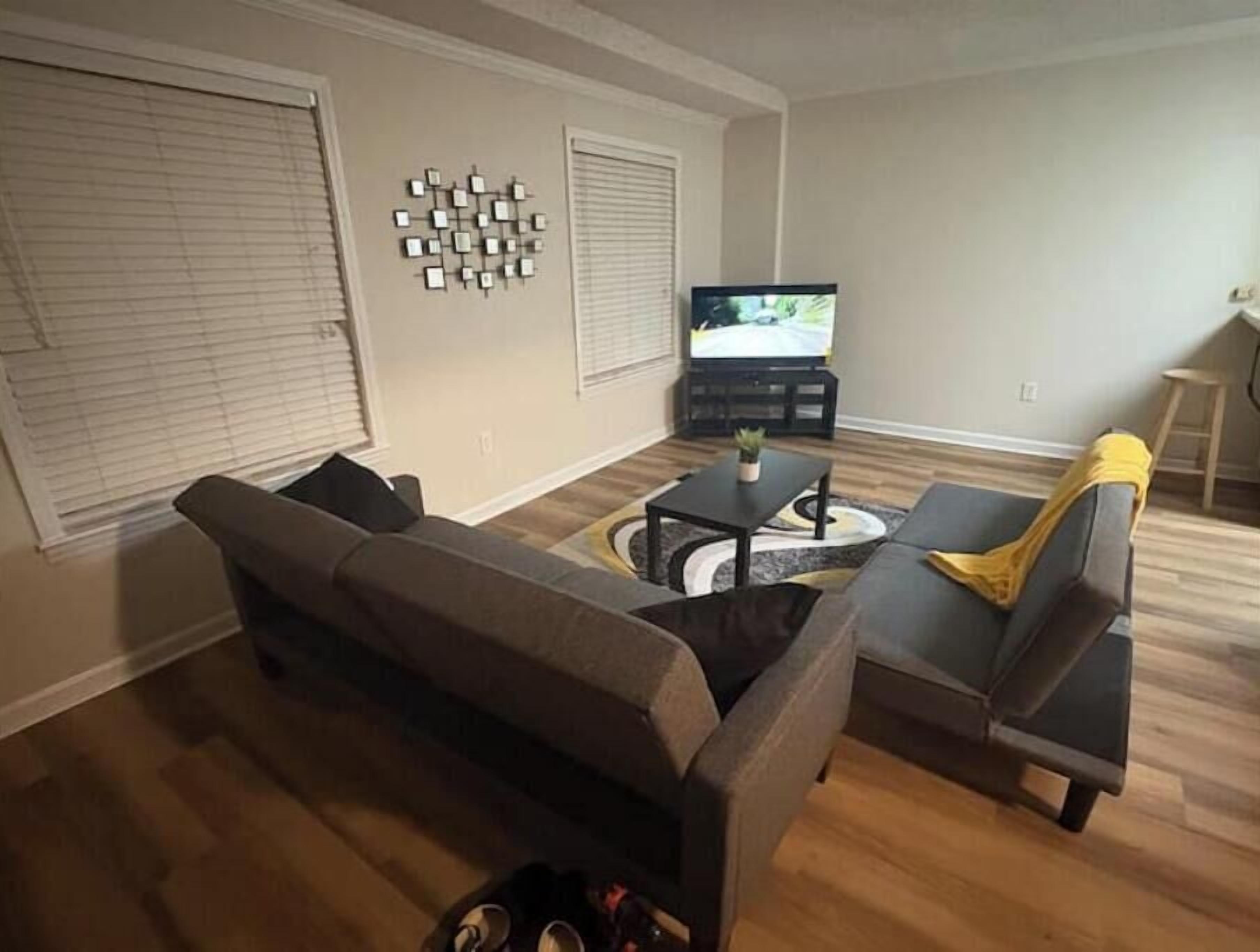 Een woonkamer met een bank, een salontafel en een televisie.