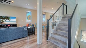 A spacious living room with a sofa, TV, and dining area. - La Concha Blvd #31 - (Port Aransas)