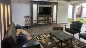 Una sala de estar con un sofá, una mesa de centro y un televisor.