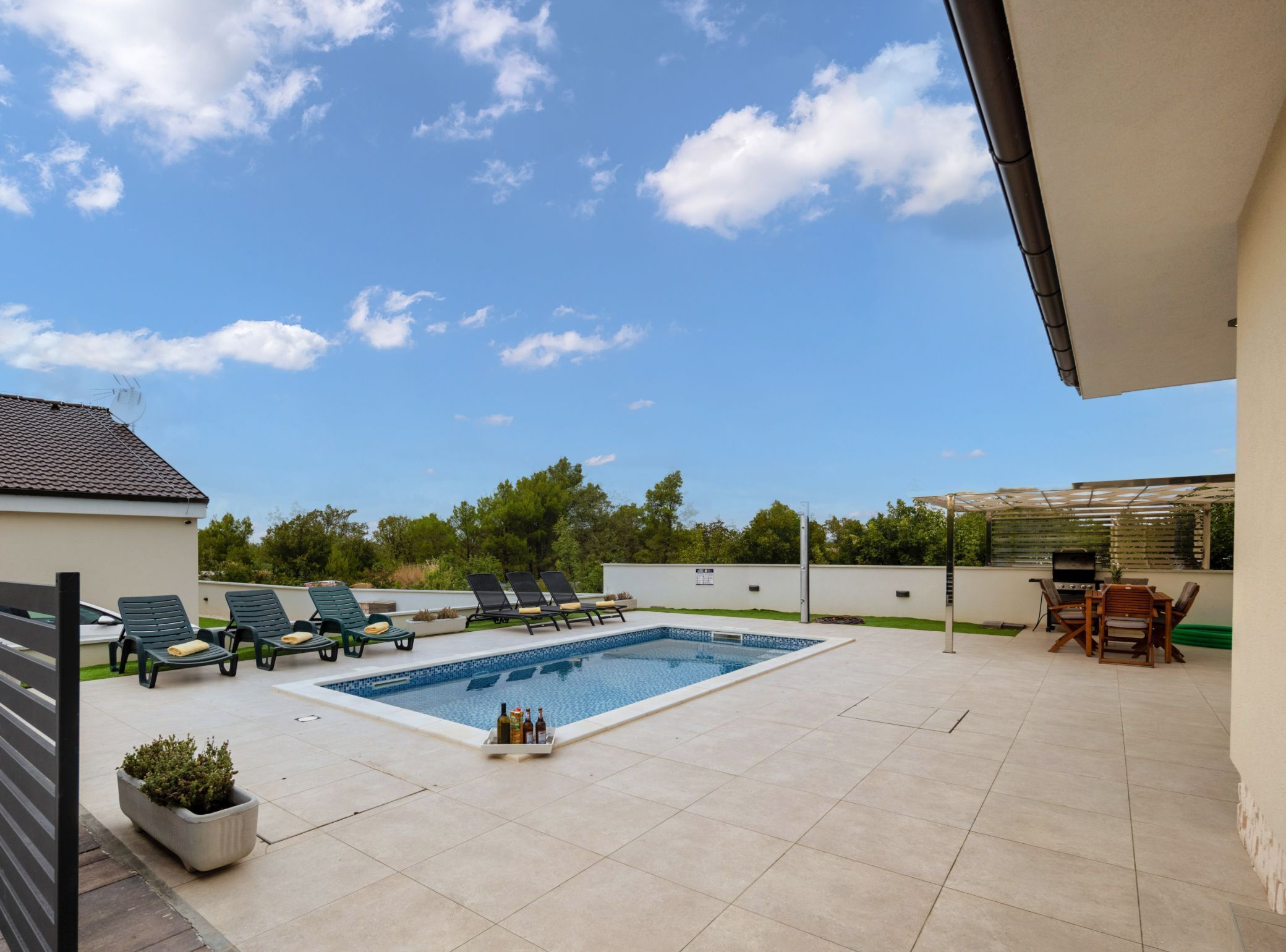 A swimming pool with lounge chairs and a barbecue area.