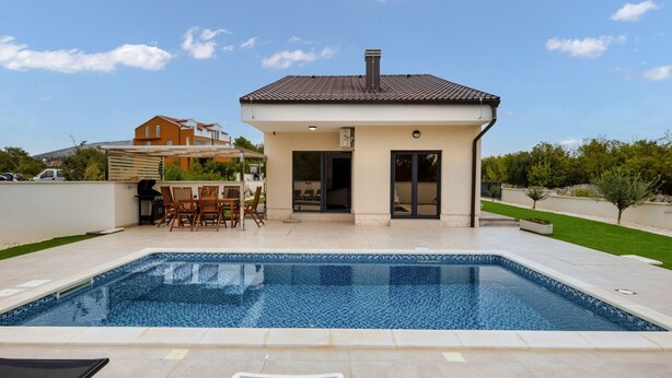 A modern house with a swimming pool, a patio with outdoor furniture, and a clear blue sky. - Villa Shaula 2 (Bilice)