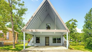 Guests can enjoy a covered porch with seating and a door with a glass panel.