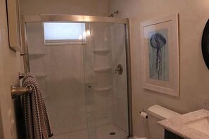Ein Badezimmer mit Duschkabine, Toilette und Waschbecken.