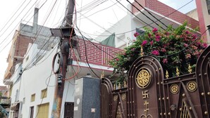 Una entrada protegida con ornamentación metálica detallada y una placa numérica.