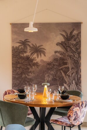 A dining area with a round table, chairs, and a wall mural.