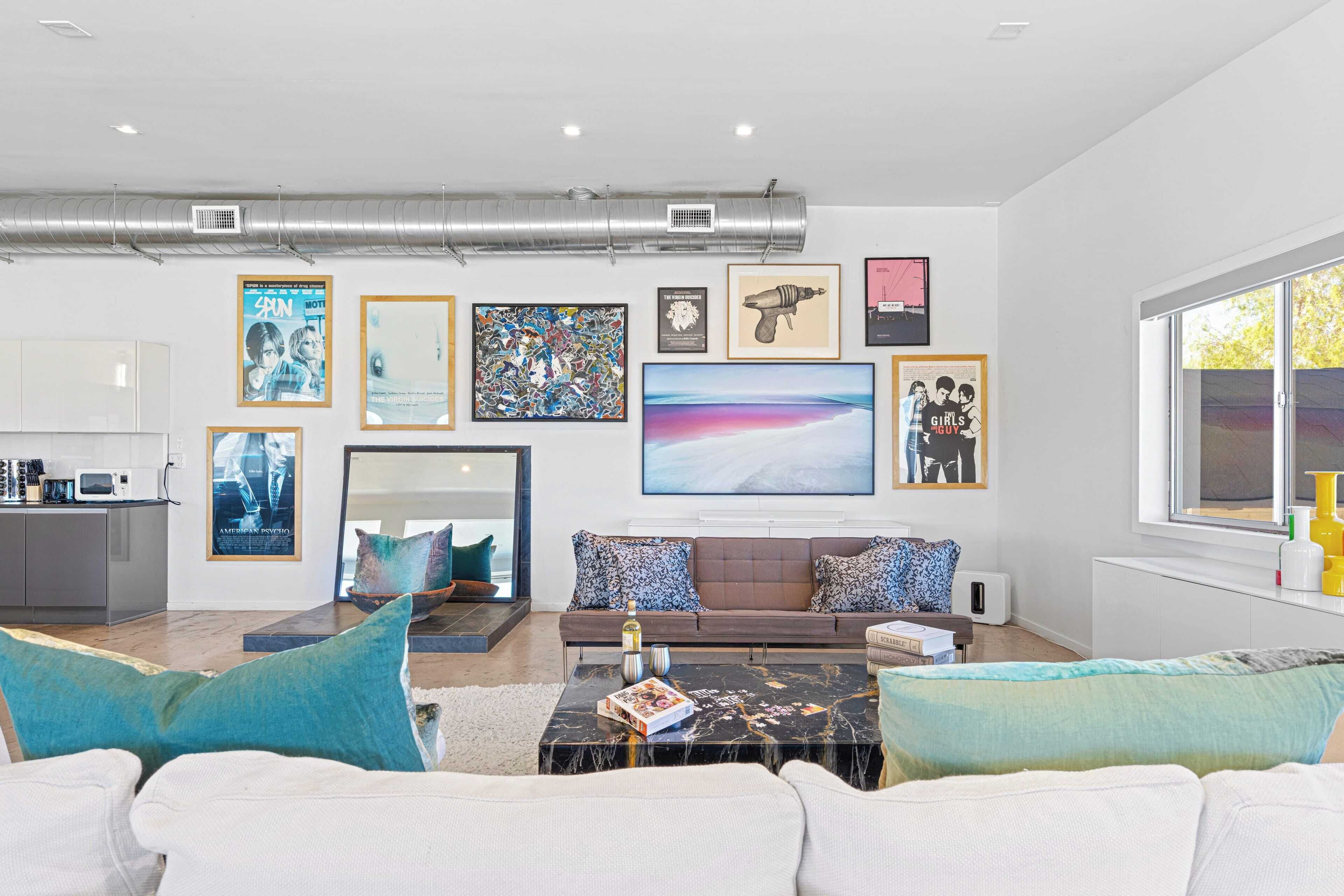 A modern living room with a sofa, coffee table, and artwork on the wall.