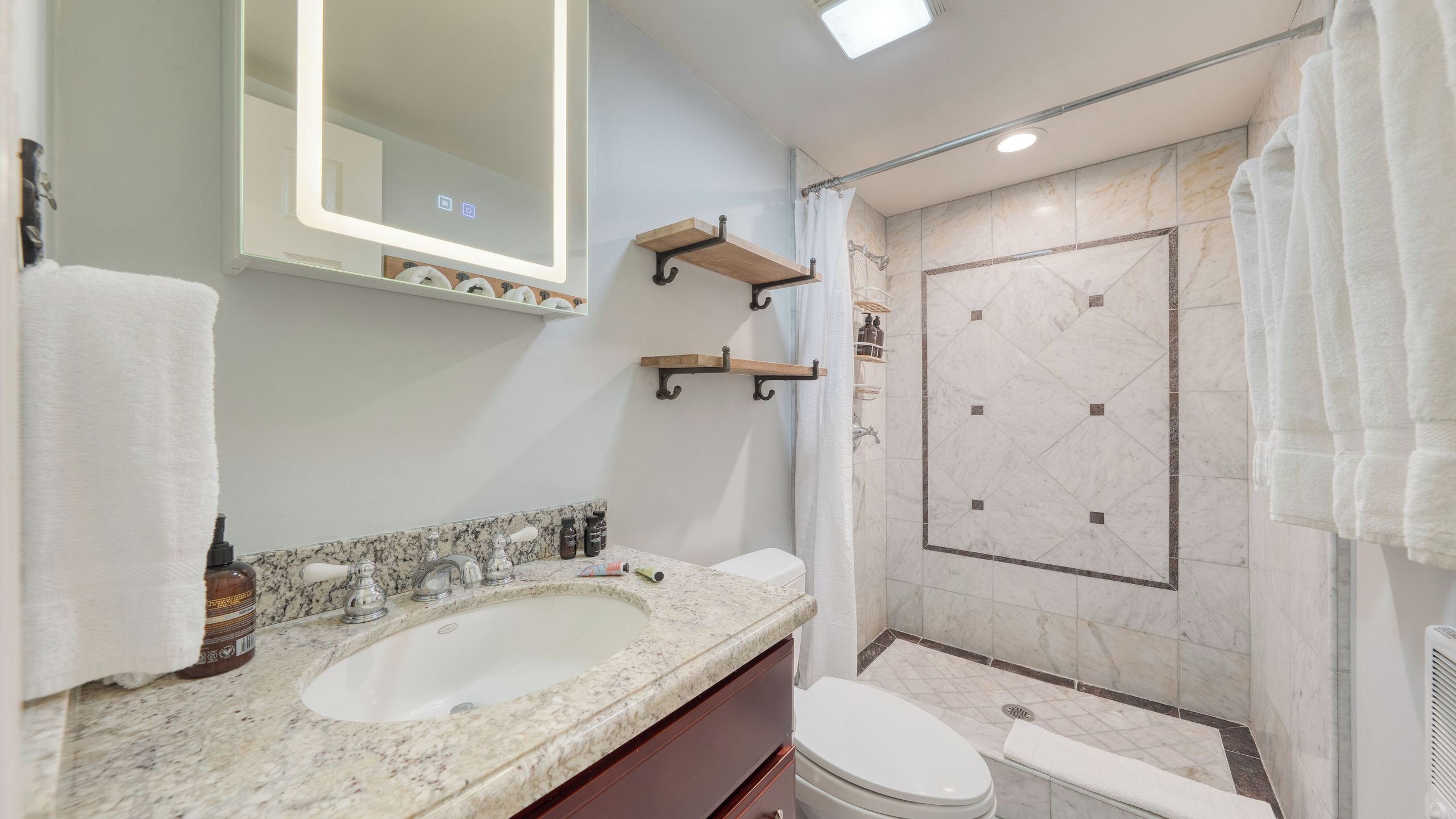 A modern bathroom with a large sink, a toilet, and a shower area.