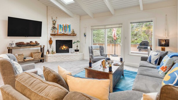 A cozy living room with a fireplace, comfortable seating, and a large TV.
