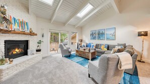 A spacious living room with a fireplace, a sofa set, a coffee table, and a large window with a view.