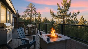 A deck with a fire pit, outdoor seating, and a grill.