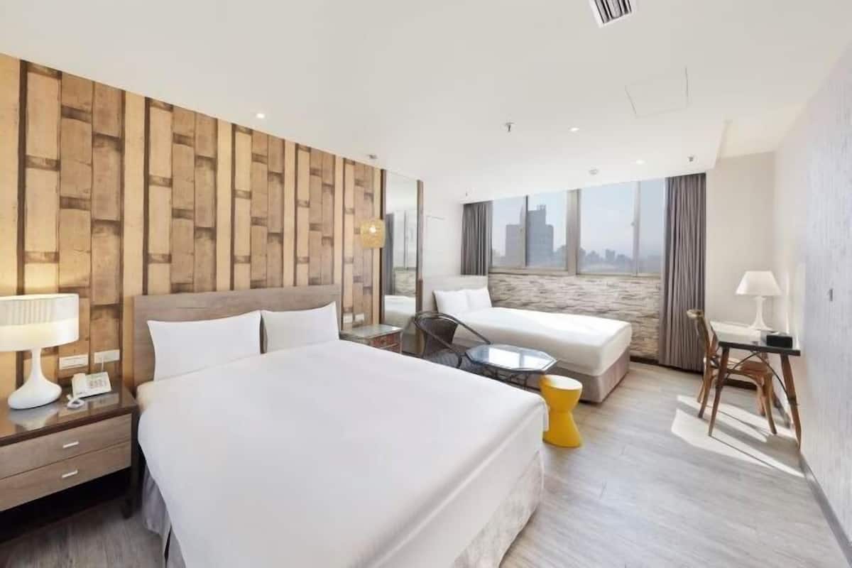 Une chambre d’hôtel moderne avec un grand lit, un canapé, une petite table et une vue sur la ville.