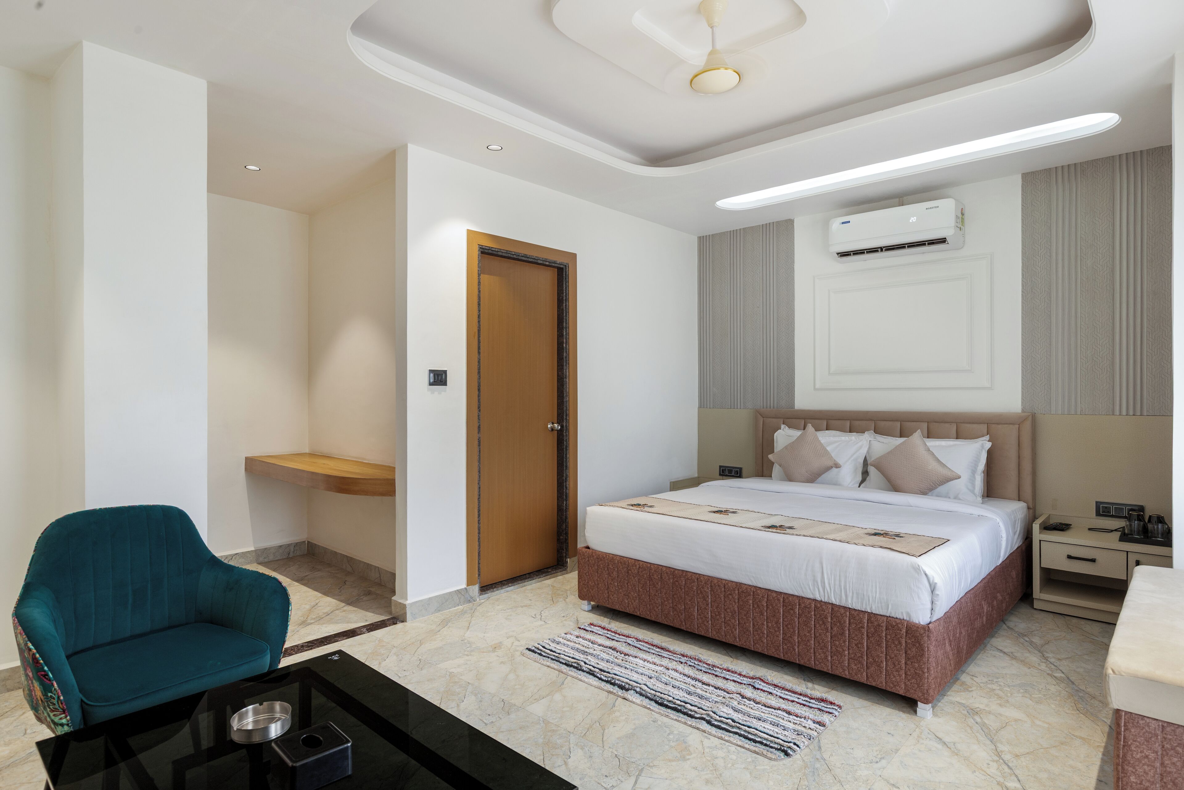 Una habitación de hotel moderna con una cama grande, un escritorio, una silla y una mesita con una bandeja.