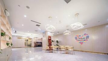 A spacious lobby with a marble floor, modern lighting fixtures, and a heart-shaped wall decoration.