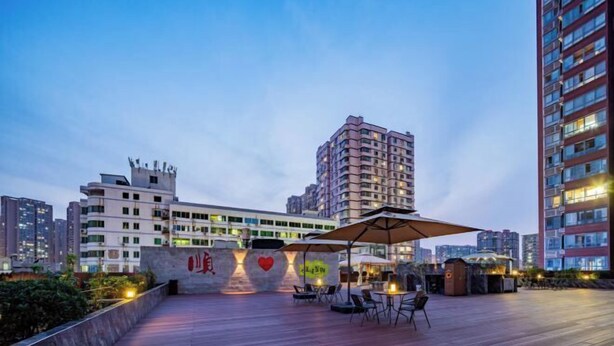 Una terrazza sul tetto con posti a sedere all'aperto, un muro decorato con un cuore e un edificio sullo sfondo.