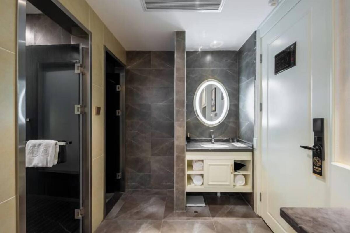 A modern bathroom with a shower, a sink with a mirror, and a towel rack.