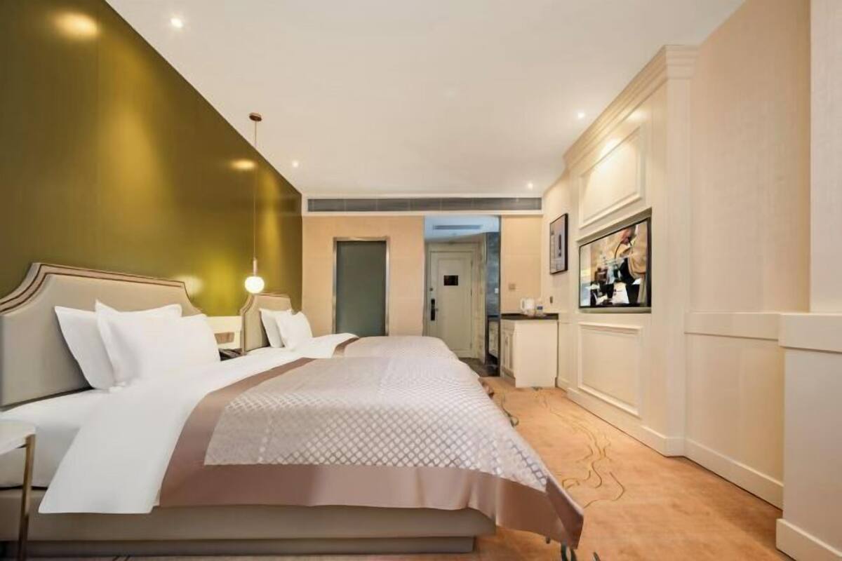 A hotel room with a large bed, bedside tables, a desk, and a chair.