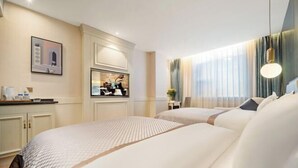 Una camera d'albergo con due letti, una scrivania con sedia, una televisione e una finestra con tende.