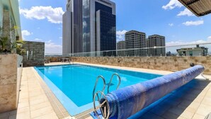 A rooftop pool with a clear view of the city skyline, including a Marriott hotel.