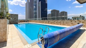 En pool på taket med fri utsikt över en Marriott-hotellbyggnad i bakgrunden.