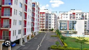 Un immeuble d’appartements moderne, doté de plusieurs étages, de balcons et d’une cour intérieure.
