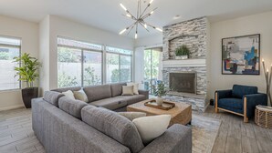 A spacious living room with a sectional sofa, a coffee table, and a fireplace. - Greyhawk - Pool - Chef's Kitchen - Golfer's Dream Location (Scottsdale)