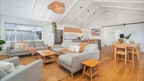 A spacious living area with a sofa, coffee table, and dining table.