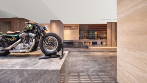 Una motocicleta expuesta en un vestíbulo moderno con un cartel que dice "EXPECT THE UNEXPECTED".