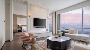 A modern living room with a large TV, comfortable seating, and a view of mountains. - InterContinental Yining by IHG (Yining)