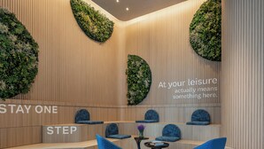 A modern lounge area with seating and a wall-mounted text. - EVEN Hotel Yining by IHG (Yining)