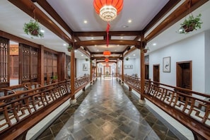 A corridor with wooden railings, a tiled floor, and hanging lanterns. - Wenyuan Shanzhuang Holiday Hotel (Xuancheng)