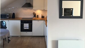 A modern kitchen with white cabinets, a wooden countertop, and a built-in oven. - Top-floor cross-through apartment with 2 terraces, in Divonne-les-Bains (Divonne-les-Bains)