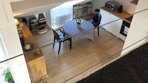 A modern kitchen with a round table, chairs, and a microwave. There is a potted plant on the table. - Top-floor cross-through apartment with 2 terraces, in Divonne-les-Bains (Divonne-les-Bains)