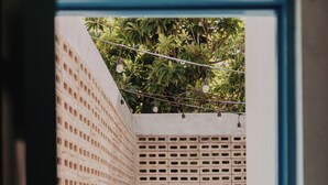 A narrow outdoor corridor with a wooden floor, a brick wall on one side, and a lattice fence on the other. There are potted plants along the corridor. - KAáN, AN OASIS WITH A GREAT LOCATION, IDEAL FOR RECONNECTING WITH NATURE. (Mérida)