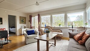 Una sala de estar acogedora con sofá, sillones, una mesa de centro y chimenea.