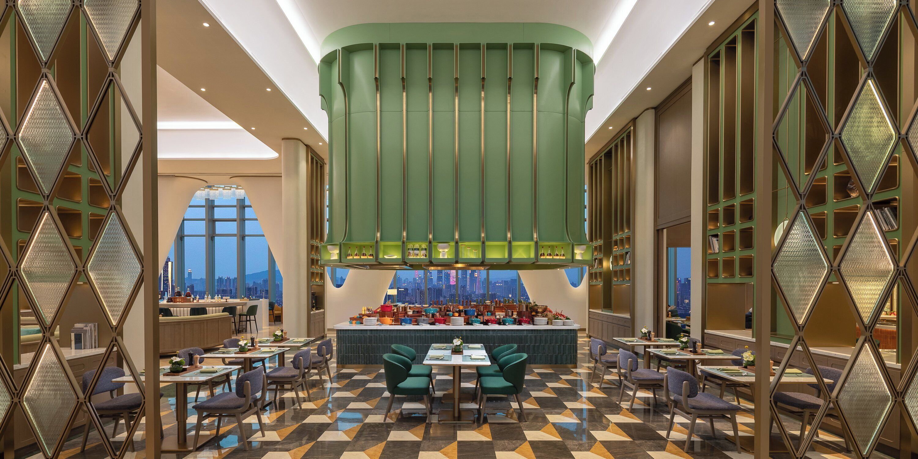 Un restaurant moderne doté d’un bar central, d’un espace salon et offrant une vue sur le paysage urbain.