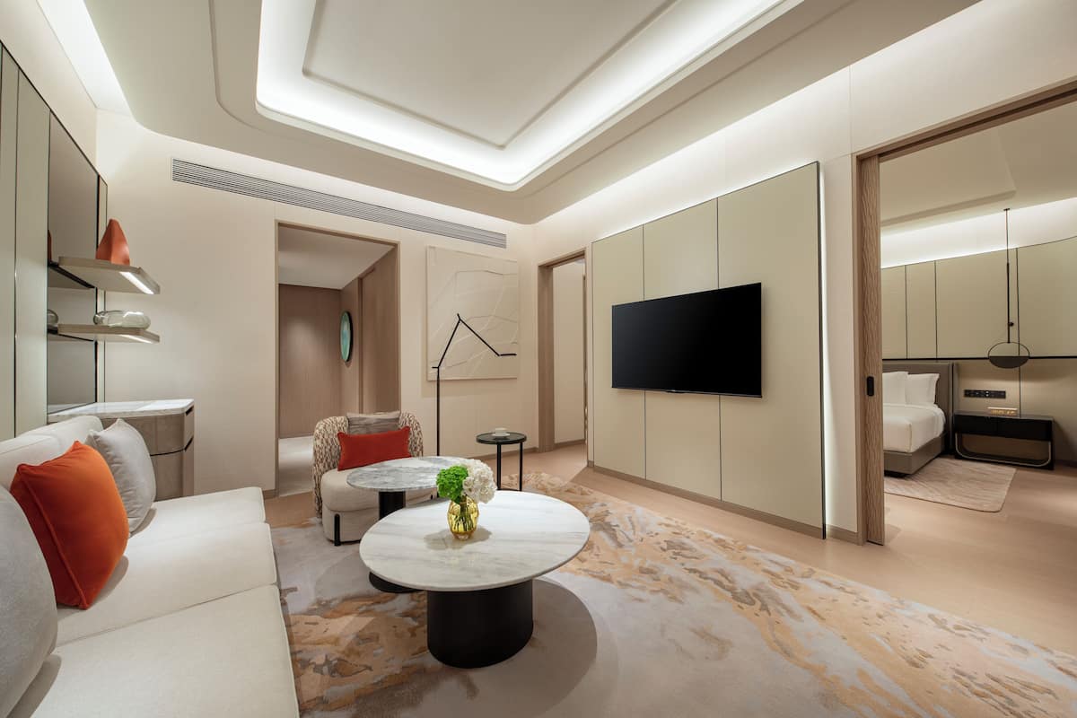 Ein modernes Wohnzimmer mit einer Couch, einem Couchtisch und einem Flachbildfernseher.