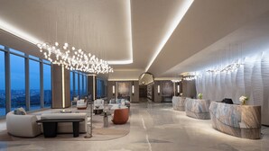 A spacious lobby with modern seating, a reception desk, and large windows offering a city view. - Crowne Plaza Guangzhou Window Of Canton by IHG (Guangzhou)