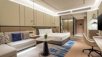 Una habitación de hotel moderna con cama, sofá, escritorio y televisor.